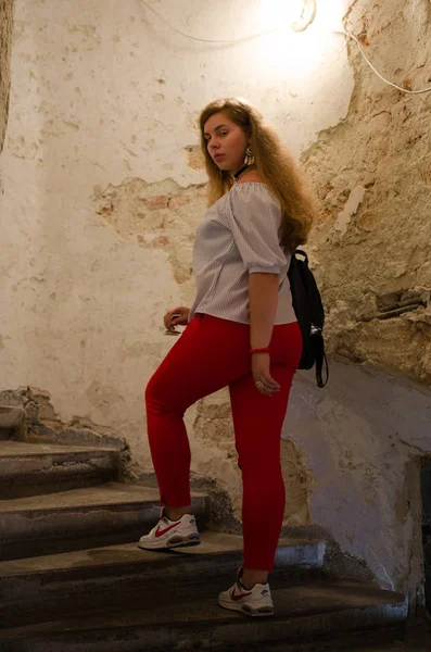 Arka planda kıvırcık saçlı genç gülümseyen kız