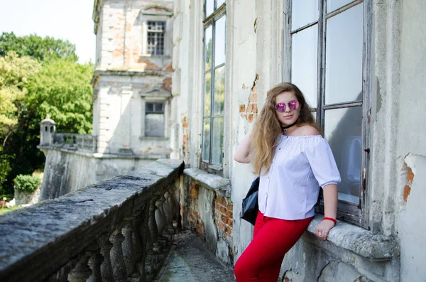 Arka planda kıvırcık saçlı genç gülümseyen kız