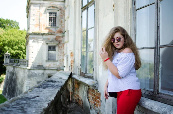 Arka planda kıvırcık saçlı genç gülümseyen kız