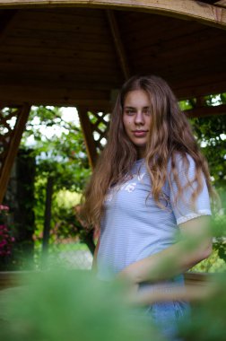 Arka planda kıvırcık saçlı genç gülümseyen kız