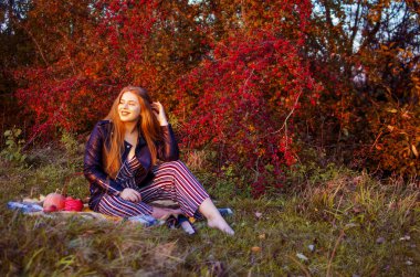 Arka planda kıvırcık saçlı genç gülümseyen kız