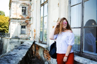 Arka planda kıvırcık saçlı genç gülümseyen kız