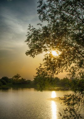Göl ve güneşin gökyüzünün muhteşem bir renkle 