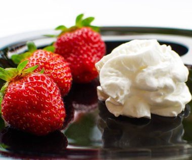 Tatlı olarak kırmızı lezzetli çilekler ve sınırlı bir arkaplanda dondurma için taze meyve suyu.