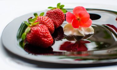 Tatlı olarak kırmızı lezzetli çilekler ve sınırlı bir arkaplanda dondurma için taze meyve suyu.