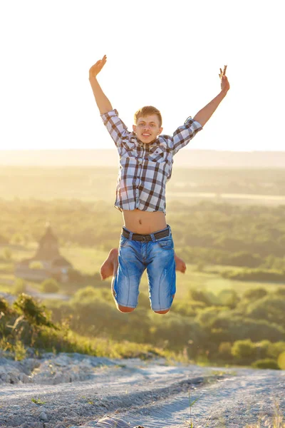 happy guy jumping to the top on the background of nature and sun concept of success and happiness