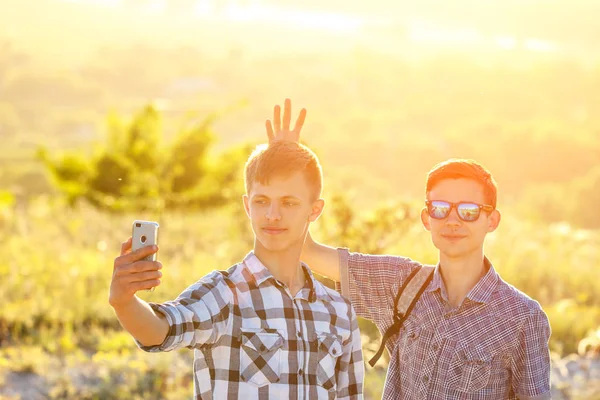 funny friends guys are photographed on phone selfie on a Sunny day