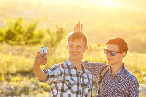 funny friends guys are photographed on phone selfie on a Sunny day