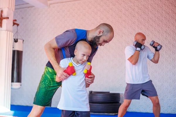 the coach teaches the boy kick Boxing.