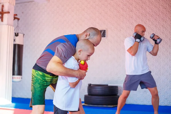 the coach teaches the boy kick Boxing.