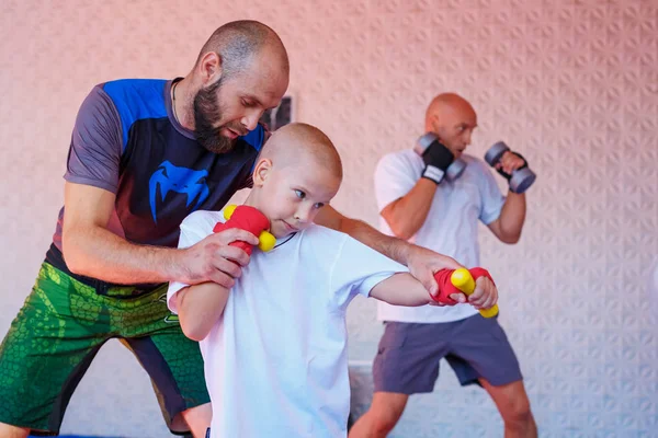 the coach teaches the boy kick Boxing.