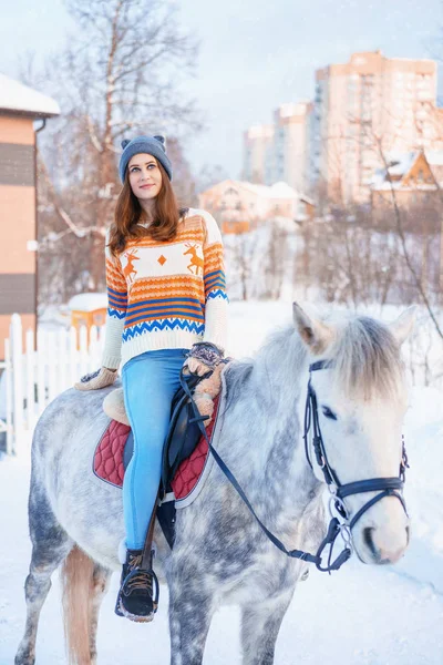 young beautiful woman in winter with beautiful white horse