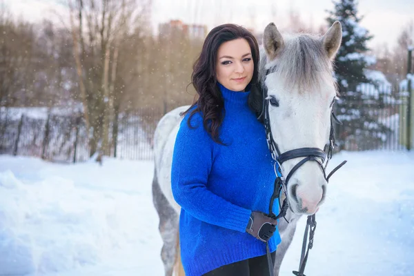 a young woman with a beautiful winter white horse