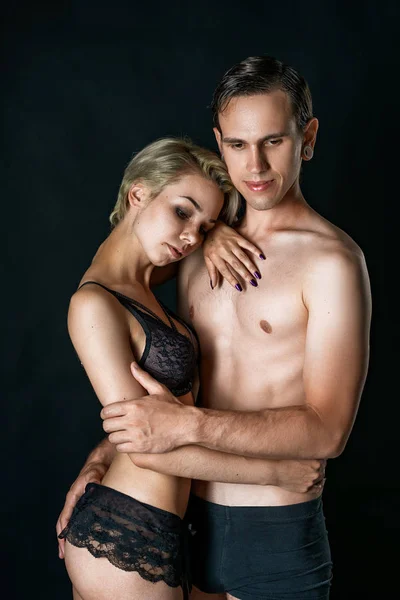 cute couple girl and guy in underwear on black background