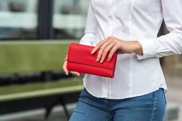 Flicka i vitt håller en röd plånbok i handen — Stockfoto