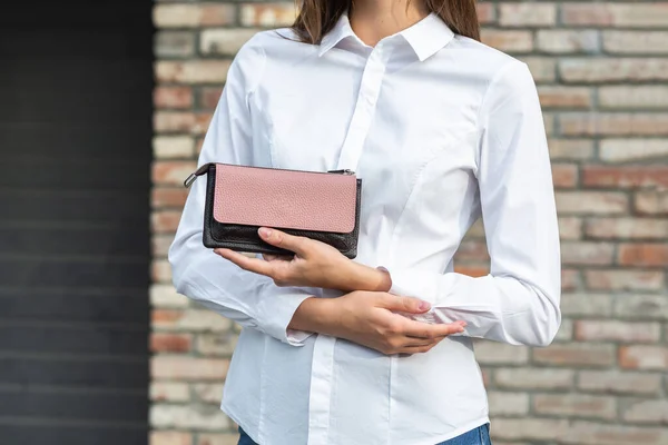 Menina de branco segura uma bolsa na mão — Fotografia de Stock