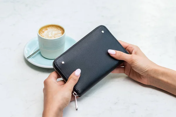Svart plånbok nära kaffekoppen på ett vitt bord — Stockfoto
