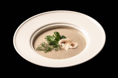 Beyaz tabakta dereotlu vejetaryen mantar çorbası.