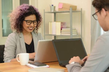 İki iş adamları konusunda konuşurken bir ofiste çalışmak.