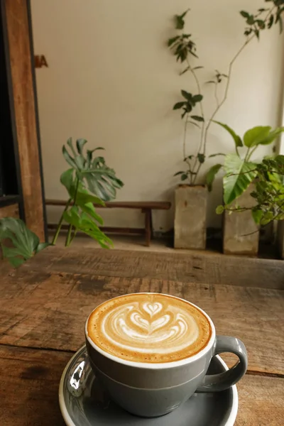 木製の背景にラテアートコーヒーを飲みながら — ストック写真