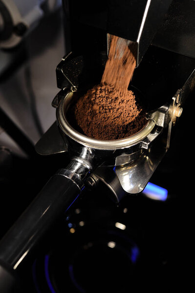 freshly ground coffee beans in a porta filter by the coffee grinder roasted make beans into a powder.