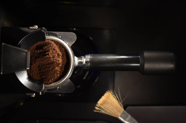 freshly ground coffee beans in a porta filter by the coffee grinder roasted make beans into a powder.