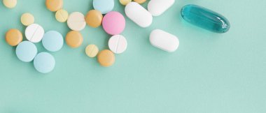 mavi arka plan üzerinde farklı renkli ilaç ve haplar