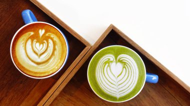 Bir fincan yeşil çay, matcha latte ve ahşap arka planda bir fincan sütlü kahve.                               