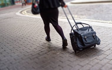 Yuvarlanan Çantayı Çeken Kadın 