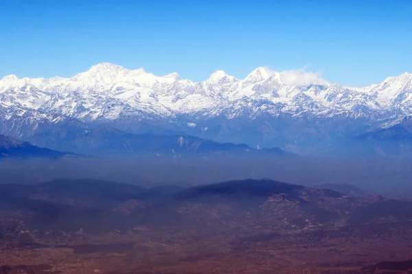 ネパール上空の雲と塵の層の上のヒマラヤ山脈の巨大な範囲 — ストック写真