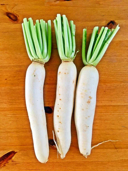 Mutfaktaki ahşap masaya üç beyaz turp serpiştiriyorum.