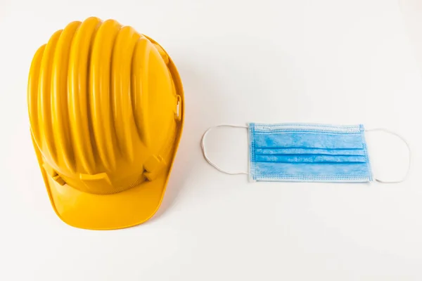 Beyaz arka planda koruyucu yüz maskesi olan güvenlik kaskı 