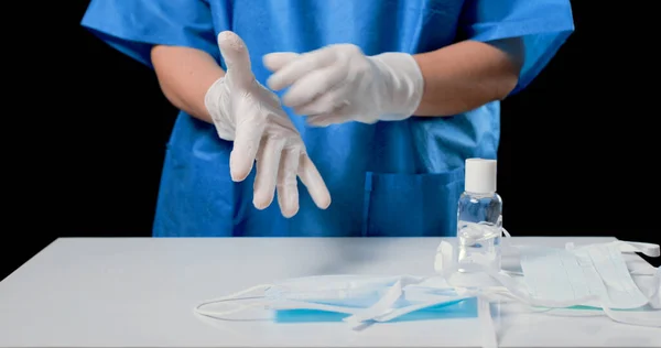 Doktor, Covid-19, 2019-NCoV ya da Coronavirus 'un yayılmasını önlemek için steril ameliyat eldivenlerini ve maskeyi düzgün bir şekilde çıkarıyor. Erkek doktor eldivenlerini çıkarıyor.