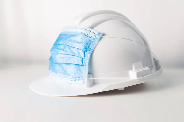 Beyaz arka planda koruyucu yüz maskesi olan güvenlik kaskı 