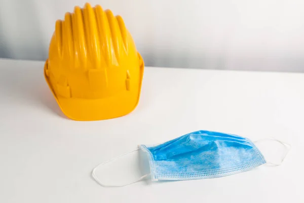 Beyaz arka planda koruyucu yüz maskesi olan güvenlik kaskı 