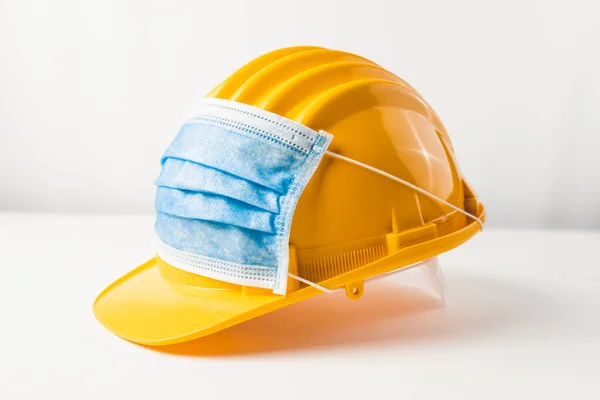 Beyaz arka planda koruyucu yüz maskesi olan güvenlik kaskı 