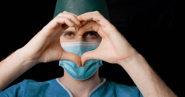 Doktor Mann Med Blå Maske Som Viser Kjærlighetstegn Med Hender stockfoto