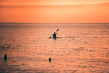 Gün batımında mavi Akdeniz 'de sörf yapmak