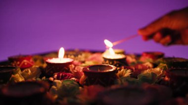 El fenerinin silueti Diwali için çiçeklerin arasında mum yakıyor..