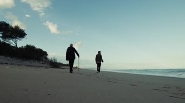 Baba ve Oğul Okyanus Kıyısındaki Babalar Günü 'nde sahilde birlikte yürürler..