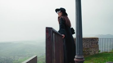 Korkuluklara Bakan Kadın Kasabanın Altındaki Doğal Manzarayı Hayran Ediyor . 