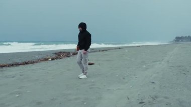 Hüzünlü kış boyunca kumların üzerinde elinde bir kitapla yürüyen yalnız bir adam.. 