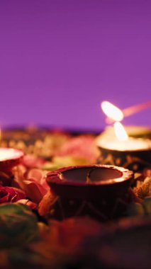 El fenerinin silueti Diwali için çiçeklerin arasında mum yakıyor..