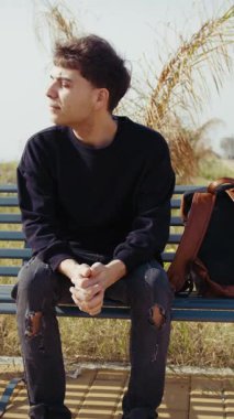 Doğadaki bankta oturan adam, havanın esintisini hissediyor ve dinleniyor. . 