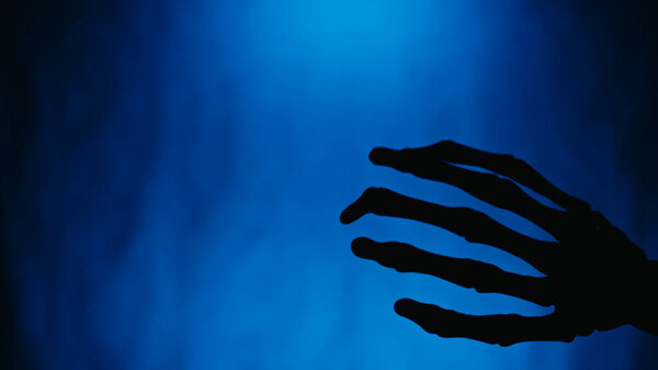 Shaking Hand Silhouette Halloween Skeleton Blue Background.
