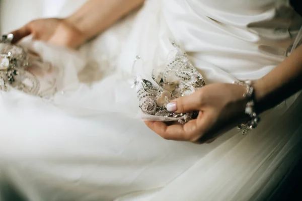 新娘手里拿着一件带花边的婚纱 — 图库照片