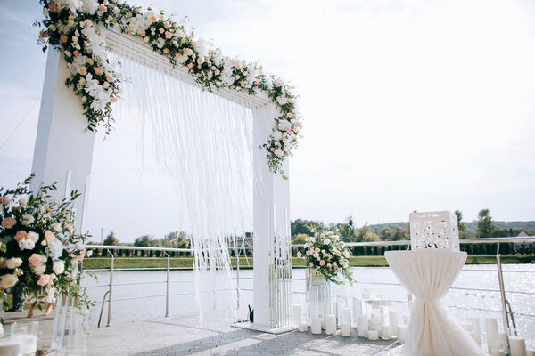 Wedding set up, outdoor wedding reception with arch on the shore of the lake