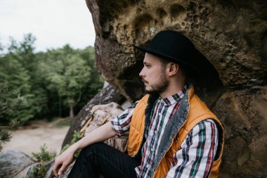 Açık hava şapkalı genç bir sakallı adamın portresi.