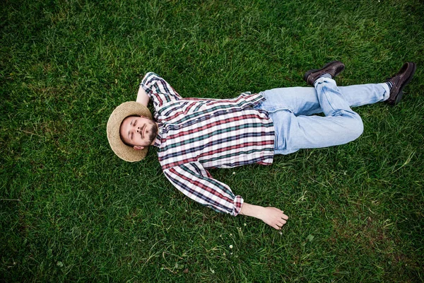 Vista Superior Joven Barbudo Con Sombrero Acostado Sobre Una Hierba —  Fotos de Stock