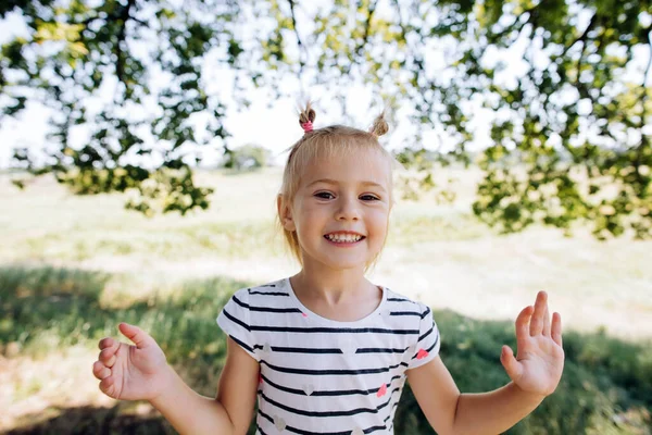 幸せな女の子で縞模様のドレスの笑顔 歯を示して カメラを見て — ストック写真